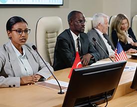 three people talking in board room setting